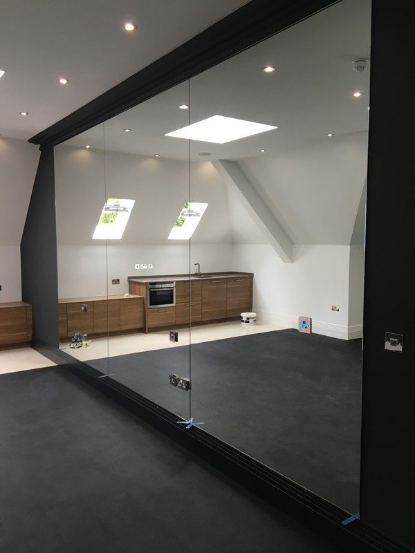 Frameless glass partition in loft conversion by North Finchley glaziers