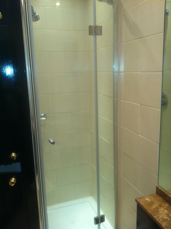 Frameless glass shower enclosure with chrome fittings in North Finchley