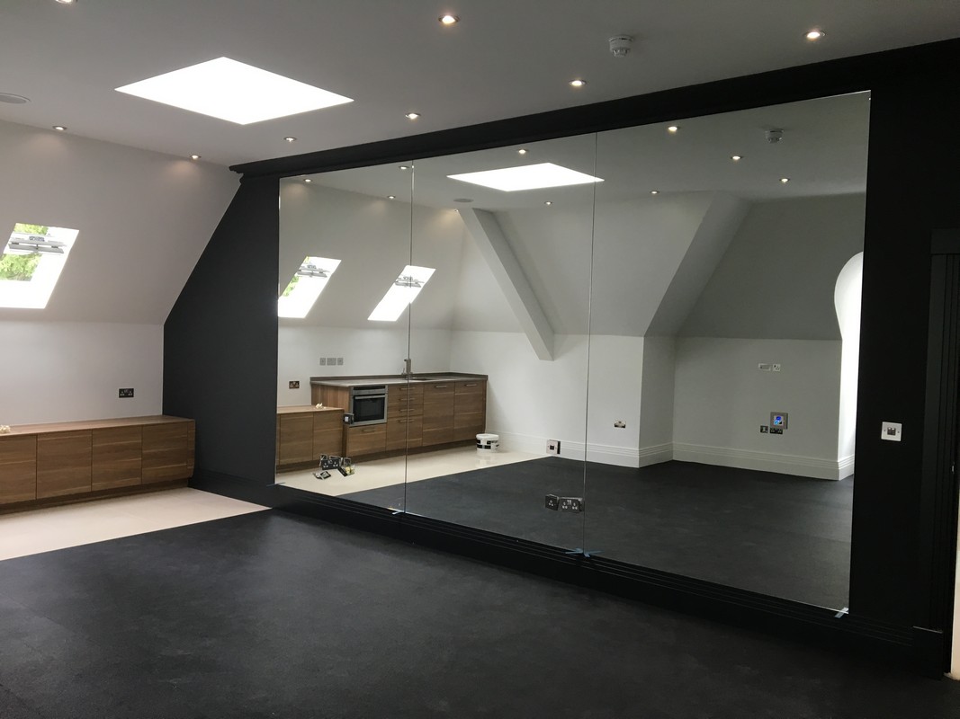Frameless glass wall dividing loft conversion in North Finchley
